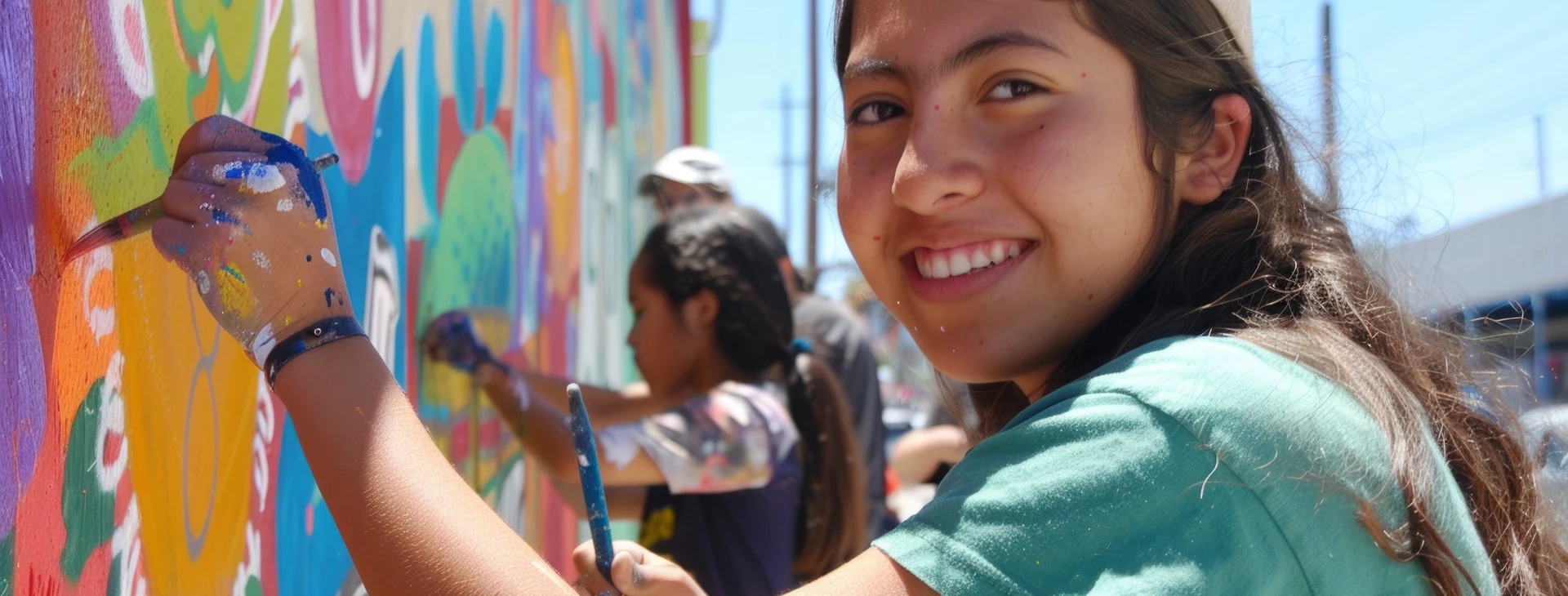 Jóvenes pintando un mural en la calle